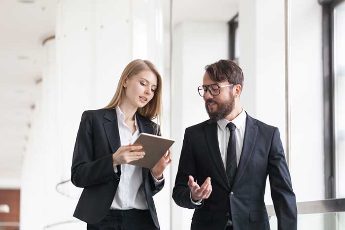 Two people discussing business strategy on an Ipad